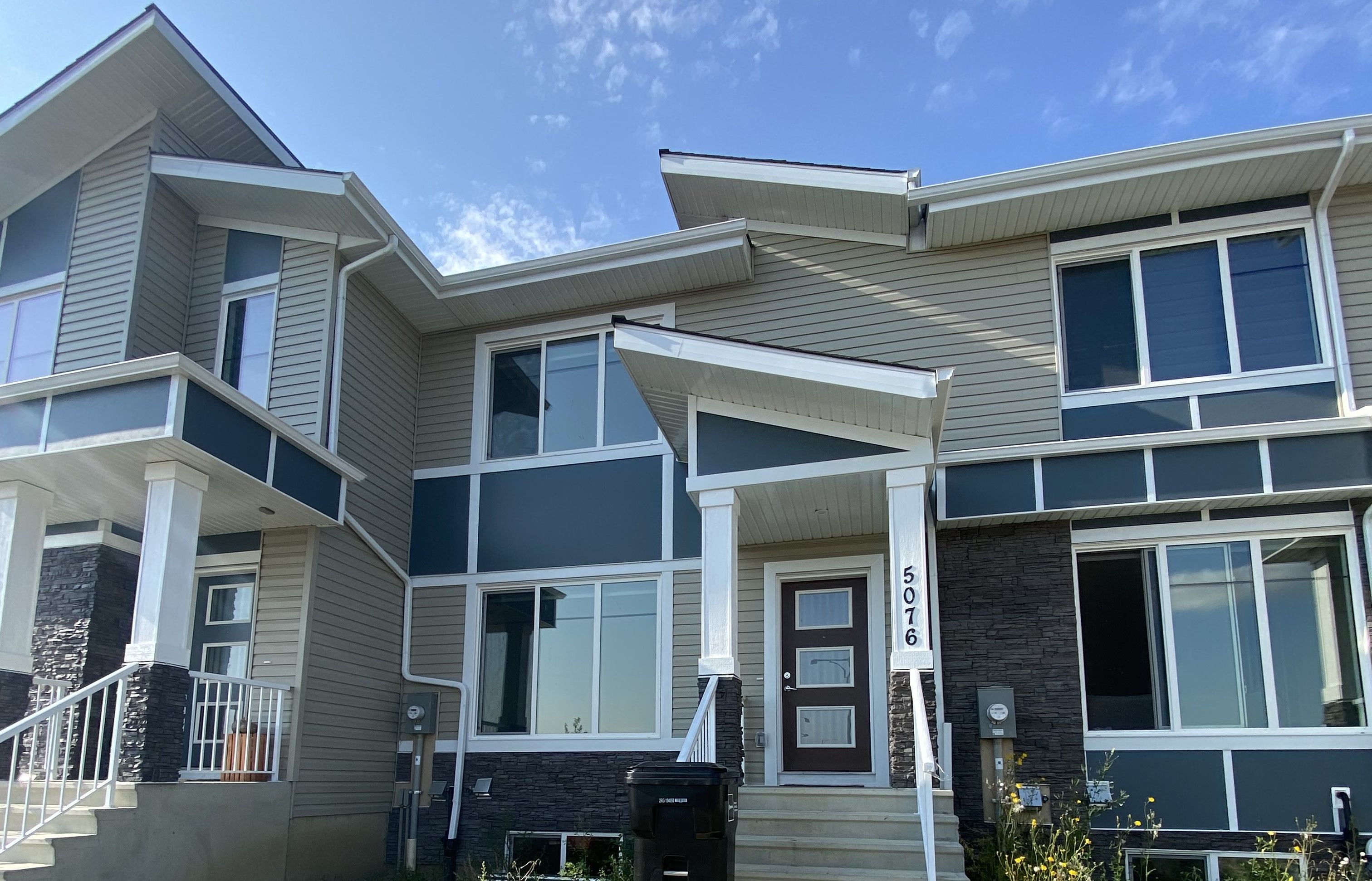 A modern two-story house with a balcony and a garage door.